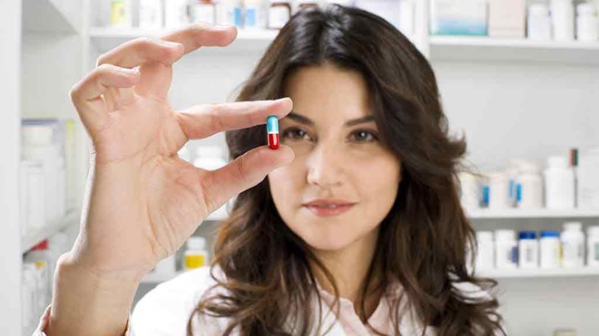 pharmacist holding a pill